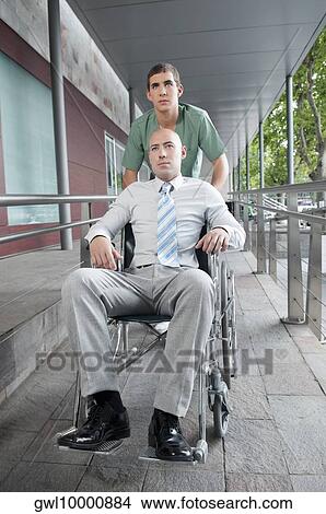 Male nurse pushing a man in wheelchair View Large Photo Image Picture - Male nurse pushing a man in wheelchair. Fotosearch