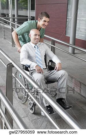 Male nurse pushing a man in wheelchair View Large Photo Image Stock Photo - Male nurse pushing a man in wheelchair. Fotosearch