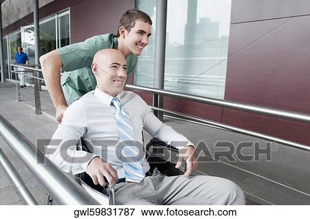 Male nurse pushing a man in wheelchair View Large Photo Image Stock Photo - Male nurse pushing a man in wheelchair. Fotosearch