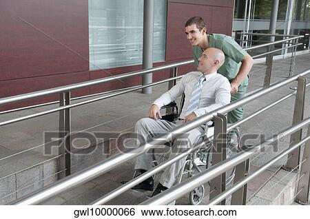Male nurse pushing a man in wheelchair View Large Photo Image Stock Photograph - Male nurse pushing a man in wheelchair. Fotosearch
