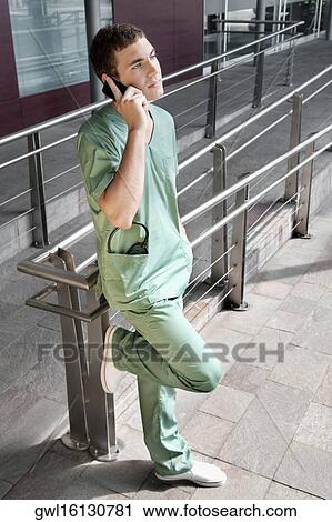Stock Image - Male nurse talking on a mobile phone. Fotosearch