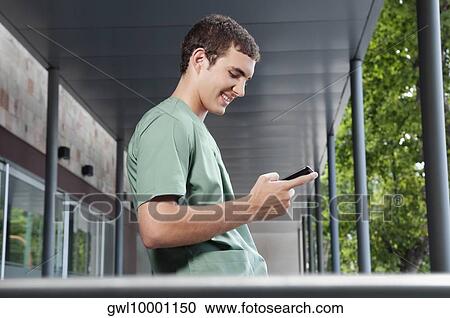 Male nurse text messaging on a mobile phone View Large Photo Image Stock Image - Male nurse text messaging on a mobile phone. Fotosearch