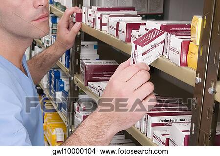 Male pharmacist checking the medicines in a medical store View Large Photo Image Picture - Male pharmacist checking the medicines in a medical store. Fotosearch