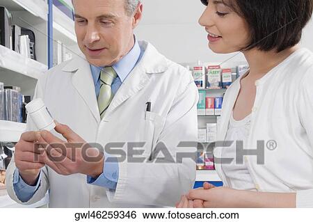 Male pharmacist discussing with a customer View Large Photo Image Stock Photograph - Male pharmacist discussing with a customer. Fotosearch