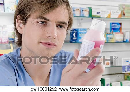 Male pharmacist holding a medicine bottle View Large Photo Image Stock Image - Male pharmacist holding a medicine bottle. Fotosearch