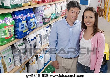 Stock Photo - Man and his daughter shopping dog food in a supermarket. Fotosearch