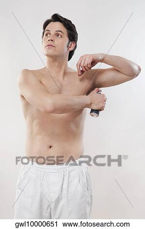 Stock Image - Man applying deodorant. Fotosearch