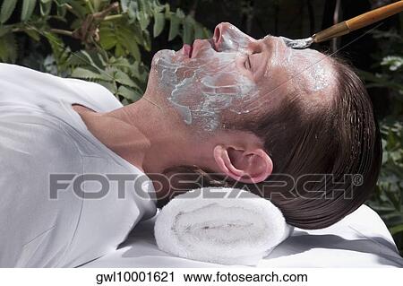 Stock Image - Man applying facial mask. Fotosearch