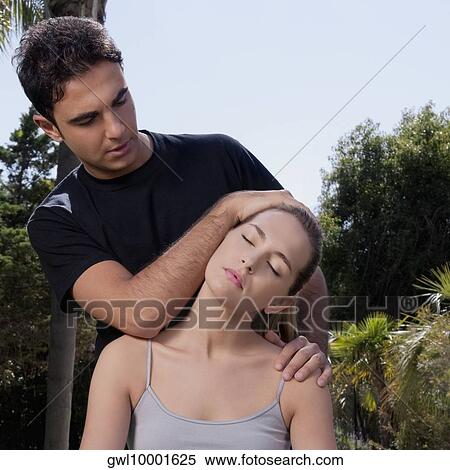 Stock Photography - Man assisting a woman during yoga practice. Fotosearch