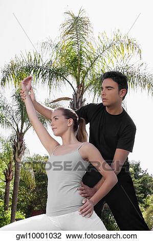 Man assisting a woman in exercise View Large Photo Image Stock Image - Man assisting a woman in exercise. Fotosearch