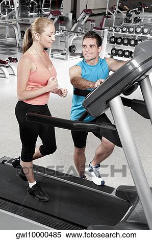 Man assisting a woman on a treadmill View Large Photo Image Stock Photography - Man assisting a woman on a treadmill. Fotosearch