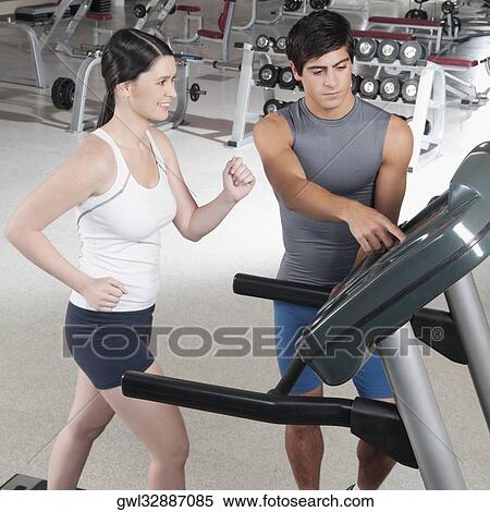 Man assisting a woman on a treadmill View Large Photo Image Stock Photography - Man assisting a woman on a treadmill. Fotosearch