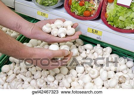 Man buying mushrooms in a supermarket View Large Photo Image Stock Image - Man buying mushrooms in a supermarket. Fotosearch