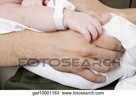 Man carrying his newborn baby View Large Photo Image Stock Image - Man carrying his newborn baby. Fotosearch