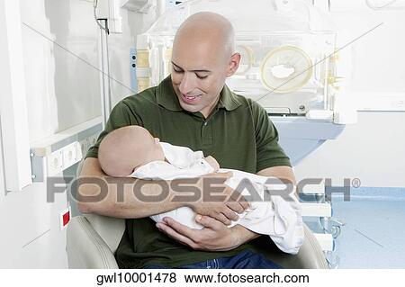 Man carrying his newborn baby View Large Photo Image Stock Photo - Man carrying his newborn baby. Fotosearch
