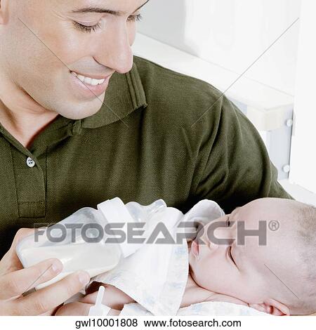 Man carrying his newborn baby View Large Photo Image Stock Photo - Man carrying his newborn baby. Fotosearch