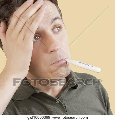 Man checking his temperature with a thermometer View Large Photo Image Stock Photo - Man checking his temperature with a thermometer. Fotosearch