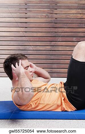 Man doing sit-ups in a gym View Large Photo Image Picture - Man doing sit-ups in a gym. Fotosearch