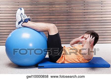 Man doing sit-ups on a fitness ball View Large Photo Image Stock Photo - Man doing sit-ups on a fitness ball. Fotosearch