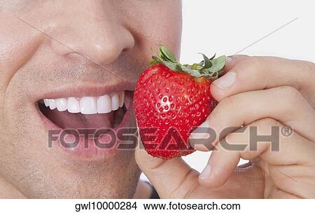 Man eating a strawberry View Large Photo Image Picture - Man eating a strawberry. Fotosearch