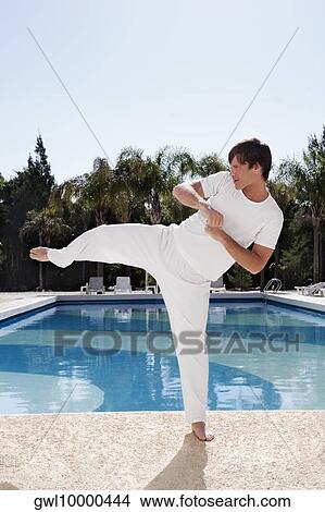 Man exercising at the poolside View Large Photo Image Picture - Man exercising at the poolside. Fotosearch