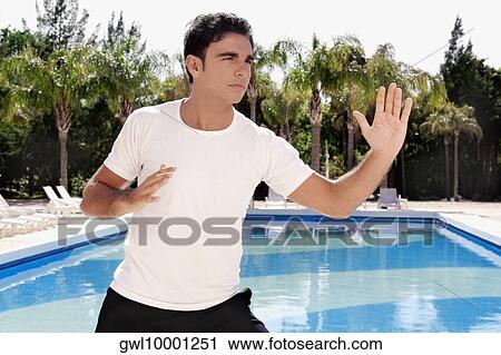 Man exercising at the poolside View Large Photo Image Stock Image - Man exercising at the poolside. Fotosearch