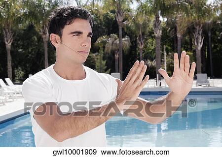 Man exercising at the poolside View Large Photo Image Stock Photo - Man exercising at the poolside. Fotosearch
