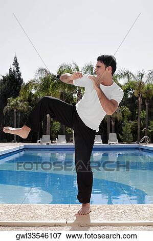 Man exercising at the poolside View Large Photo Image Stock Photo - Man exercising at the poolside. Fotosearch