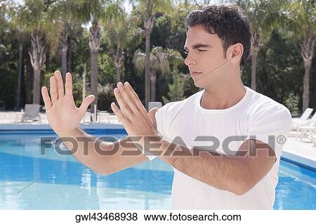 Man exercising at the poolside View Large Photo Image Stock Photo - Man exercising at the poolside. Fotosearch
