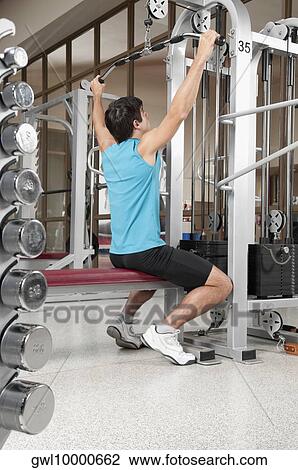 Man exercising in a gym View Large Photo Image Stock Image - Man exercising in a gym. Fotosearch