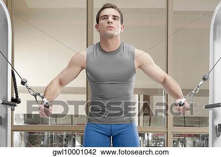 Man exercising in a gym View Large Photo Image Stock Image - Man exercising in a gym. Fotosearch