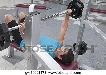 Stock Image - Man exercising in a gym. Fotosearch