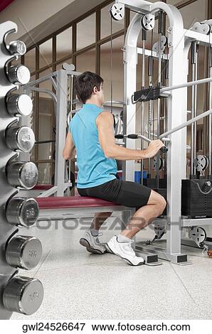 Stock Photo - Man exercising in a gym. Fotosearch
