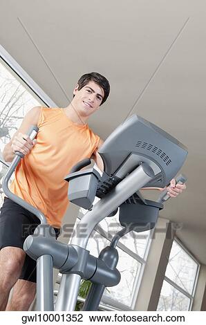 Man exercising on a stepping machine in a gym View Large Photo Image Stock Image - Man exercising on a stepping machine in a gym. Fotosearch