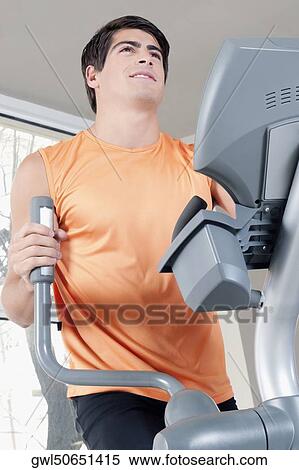Man exercising on a stepping machine in a gym View Large Photo Image Stock Photography - Man exercising on a stepping machine in a gym. Fotosearch