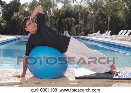 Man exercising with a fitness ball at the poolside View Large Photo Image Stock Photo - Man exercising with a fitness ball at the poolside. Fotosearch