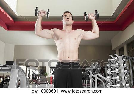 Man exercising with dumbbells in a gym View Large Photo Image Stock Image - Man exercising with dumbbells in a gym. Fotosearch