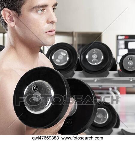 Man exercising with dumbbells in a gym View Large Photo Image Stock Image - Man exercising with dumbbells in a gym. Fotosearch