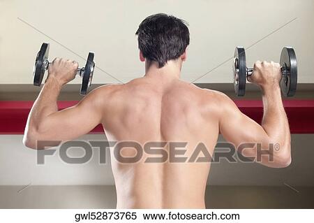 Man exercising with dumbbells in a gym View Large Photo Image Stock Photography - Man exercising with dumbbells in a gym. Fotosearch