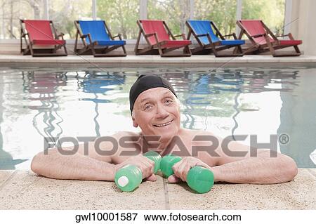 Man exercising with dumbbells in a swimming pool View Large Photo Image Stock Photo - Man exercising with dumbbells in a swimming pool. Fotosearch