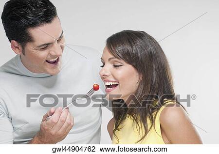 Man feeding woman a cherry tomato View Large Photo Image Stock Image - Man feeding woman a cherry tomato. Fotosearch