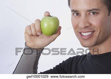 Man holding a green apple View Large Photo Image Stock Photo - Man holding a green apple. Fotosearch