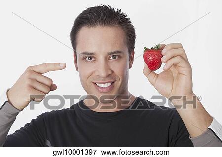 Man holding a strawberry View Large Photo Image Stock Photo - Man holding a strawberry. Fotosearch