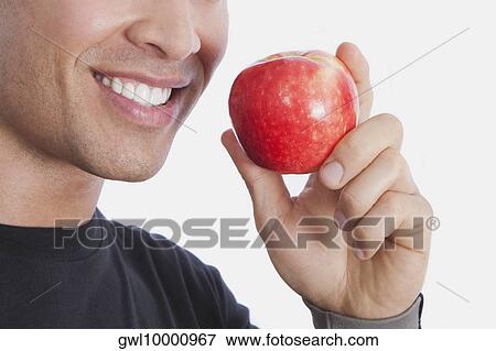 Man holding an apple View Large Photo Image Stock Photo - Man holding an apple. Fotosearch