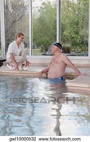 Man in a swimming pool and talking to a health worker View Large Photo Image Stock Image - Man in a swimming pool and talking to a health worker. Fotosearch