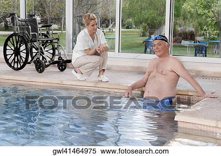 Man in a swimming pool with a health worker at poolside View Large Photo Image Stock Photography - Man in a swimming pool with a health worker at poolside. Fotosearch