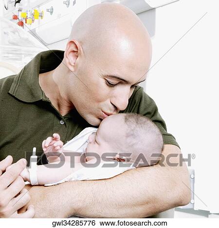 Stock Photograph - Man kissing his newborn baby. Fotosearch