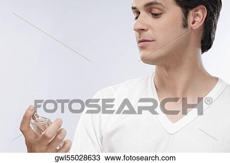 Man looking at a perfume bottle View Large Photo Image Stock Image - Man looking at a perfume bottle. Fotosearch