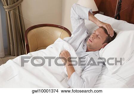 Picture - Man lying in a hospital bed. Fotosearch