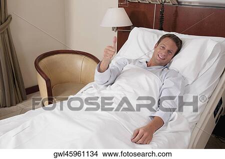 Man lying in a hospital bed View Large Photo Image Picture - Man lying in a hospital bed. Fotosearch